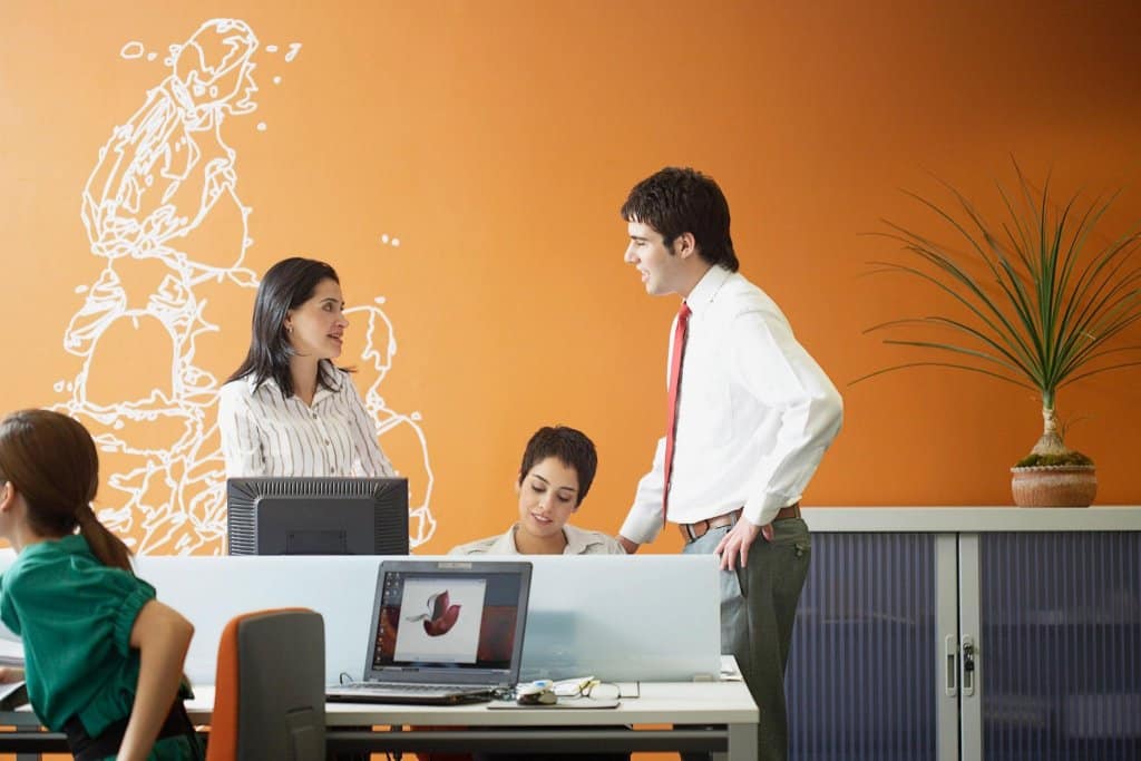 a man and two women in an office setting