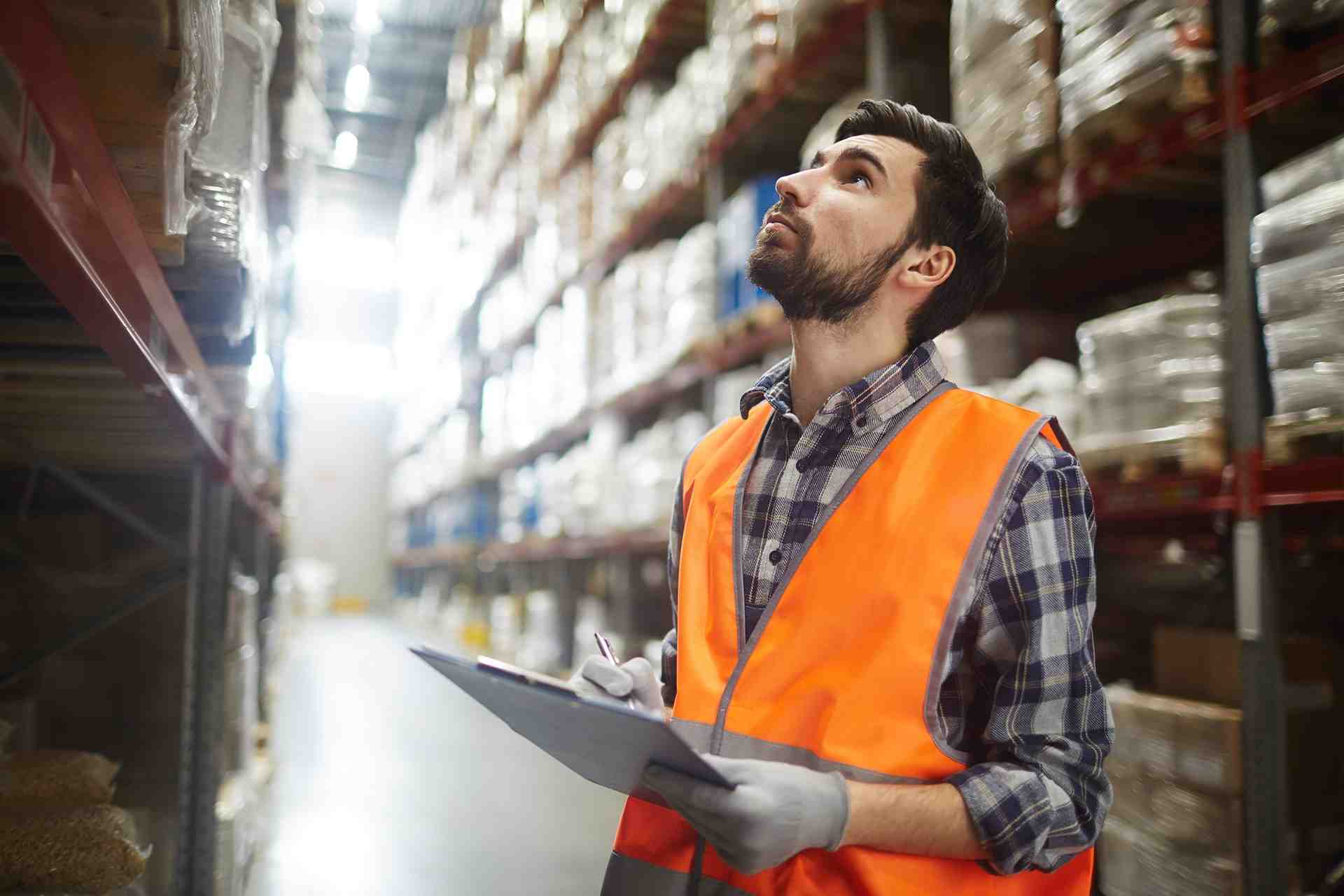 a man in an orange vest is holding a clipboard