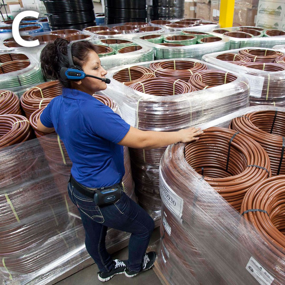 a woman wearing headphones standing in front of stacks of wires