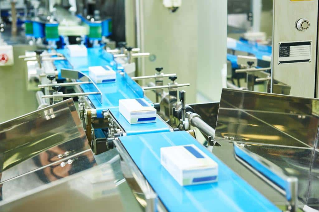 a conveyor belt with blue and white boxes on it