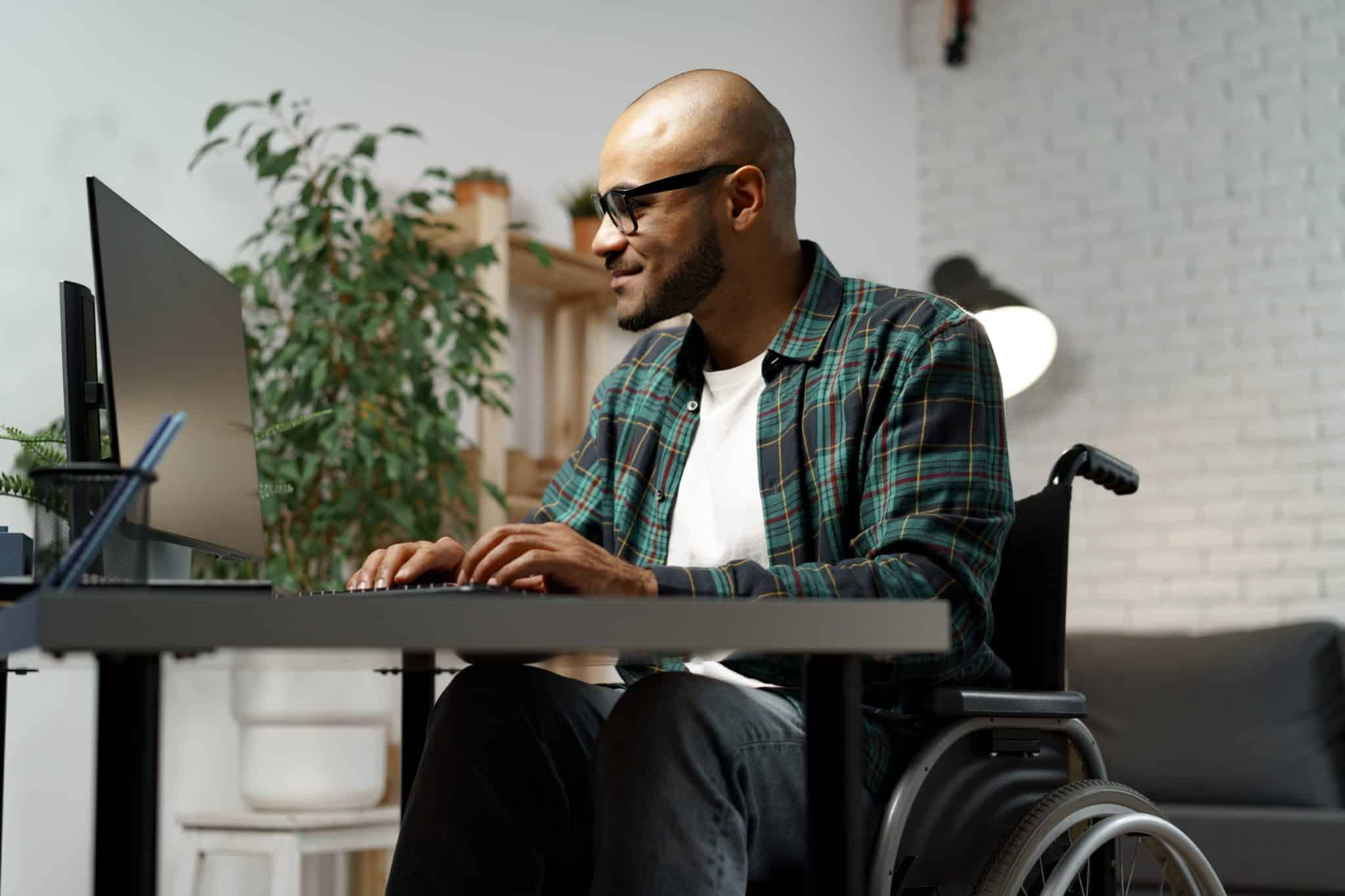a man in a wheelchair using a laptop computer