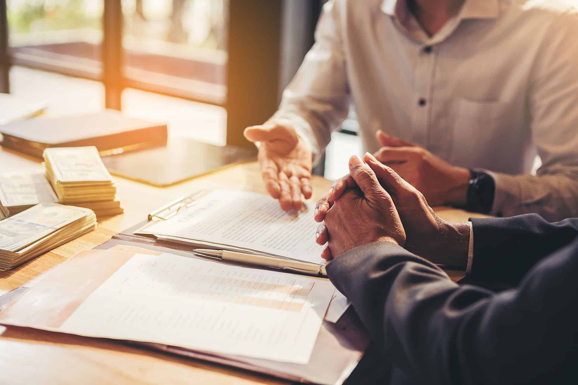 two people sitting at a table with papers