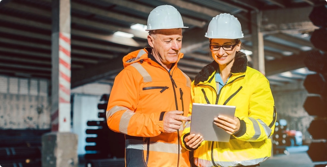 two people wearing hard hats and safety jackets