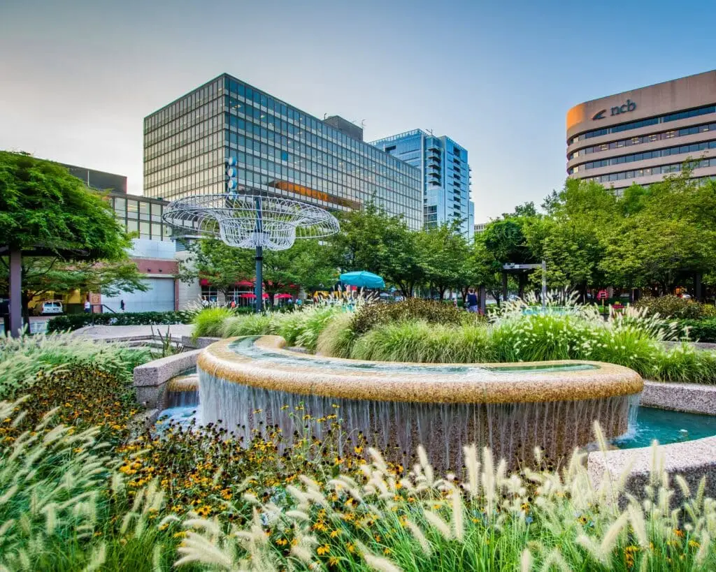 Sap Business One Arlington Virginia 4 a fountain in the middle of a park with tall buildings in the background