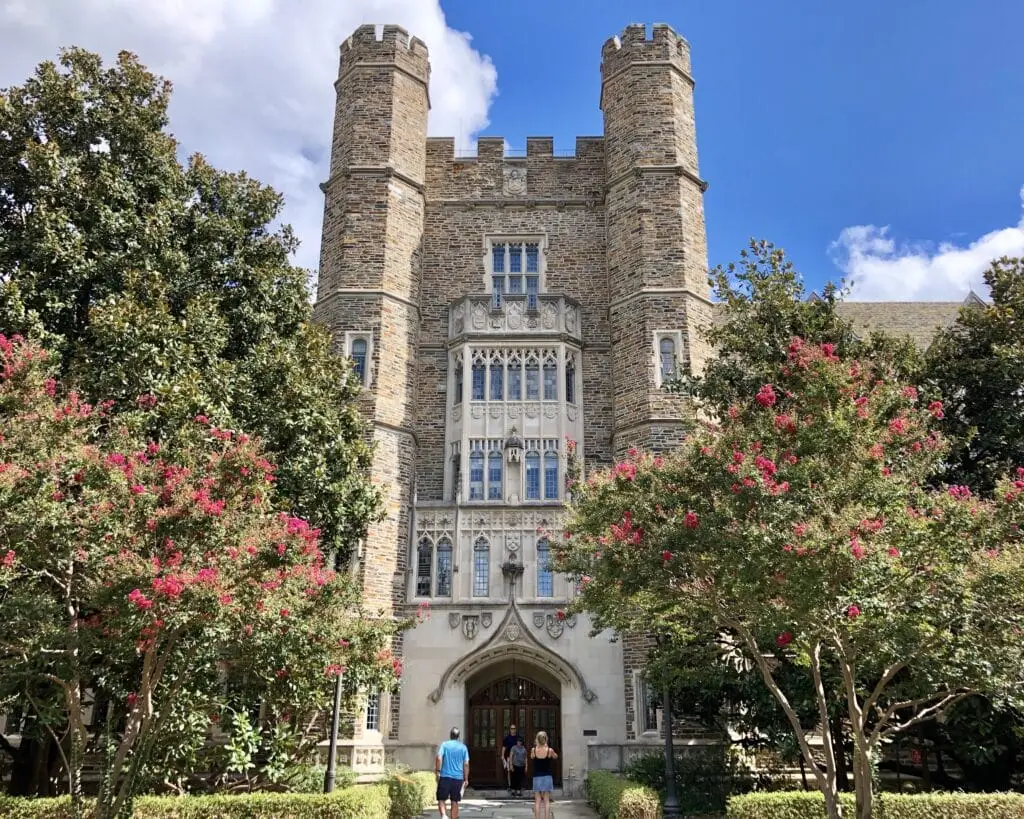 two people are walking towards a castle like building
