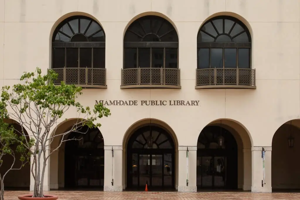 a tree in front of a building with arched windows