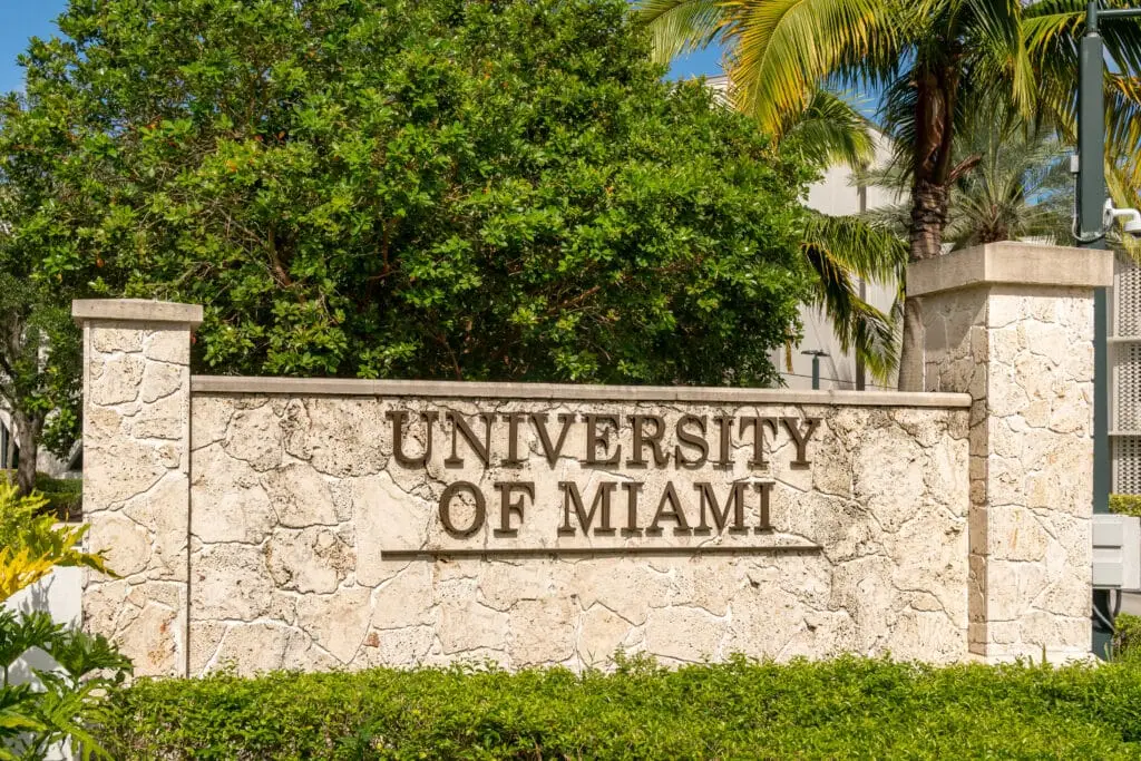 the university of miami sign in front of some trees