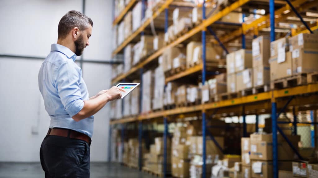 a man in a warehouse looking at a tablet