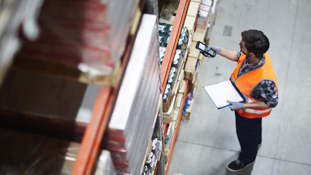 a man in an orange vest is looking at items