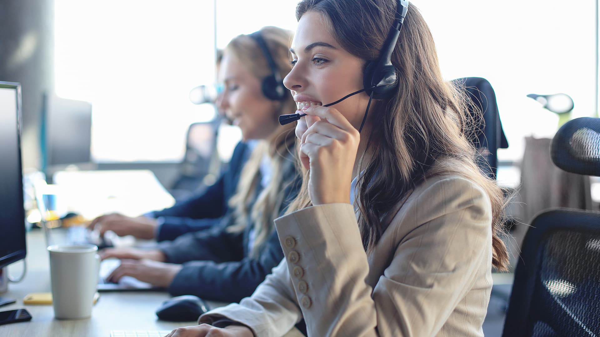 a woman sitting at a desk with headphones on
