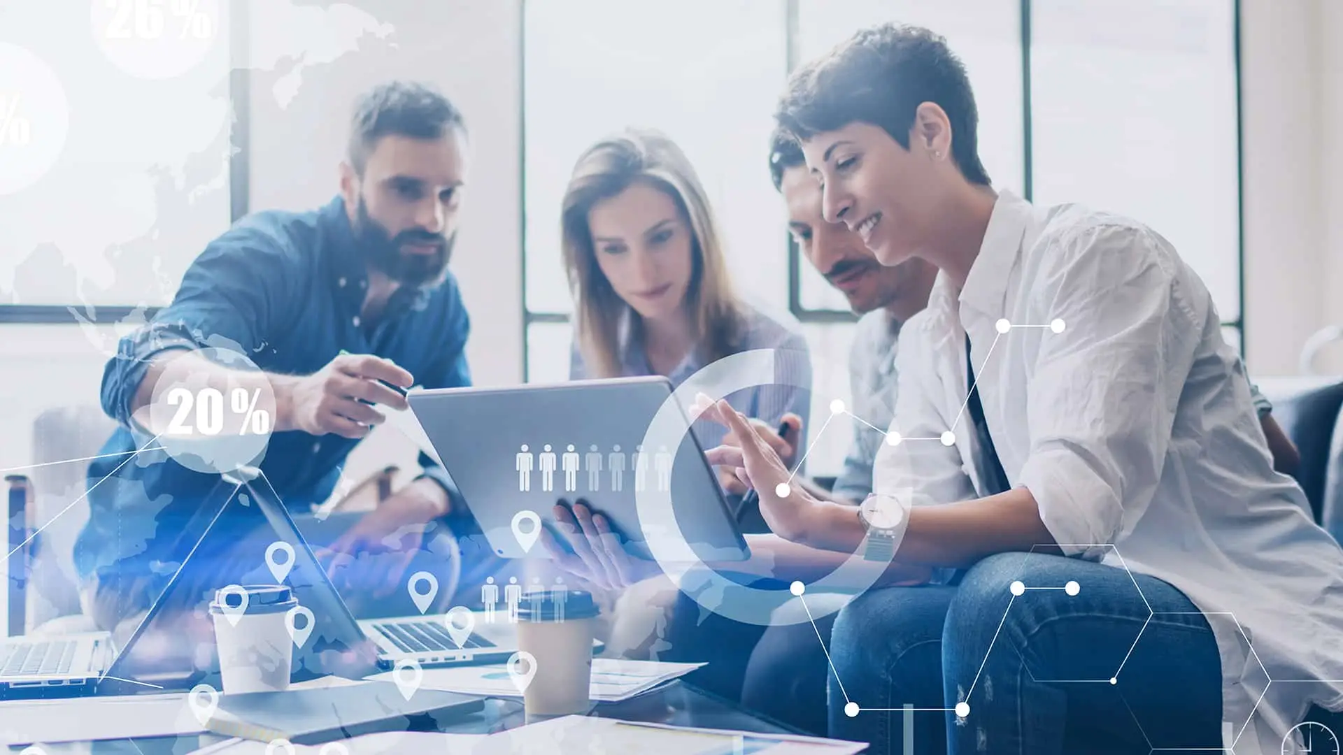 three people sitting on a couch looking at a tablet