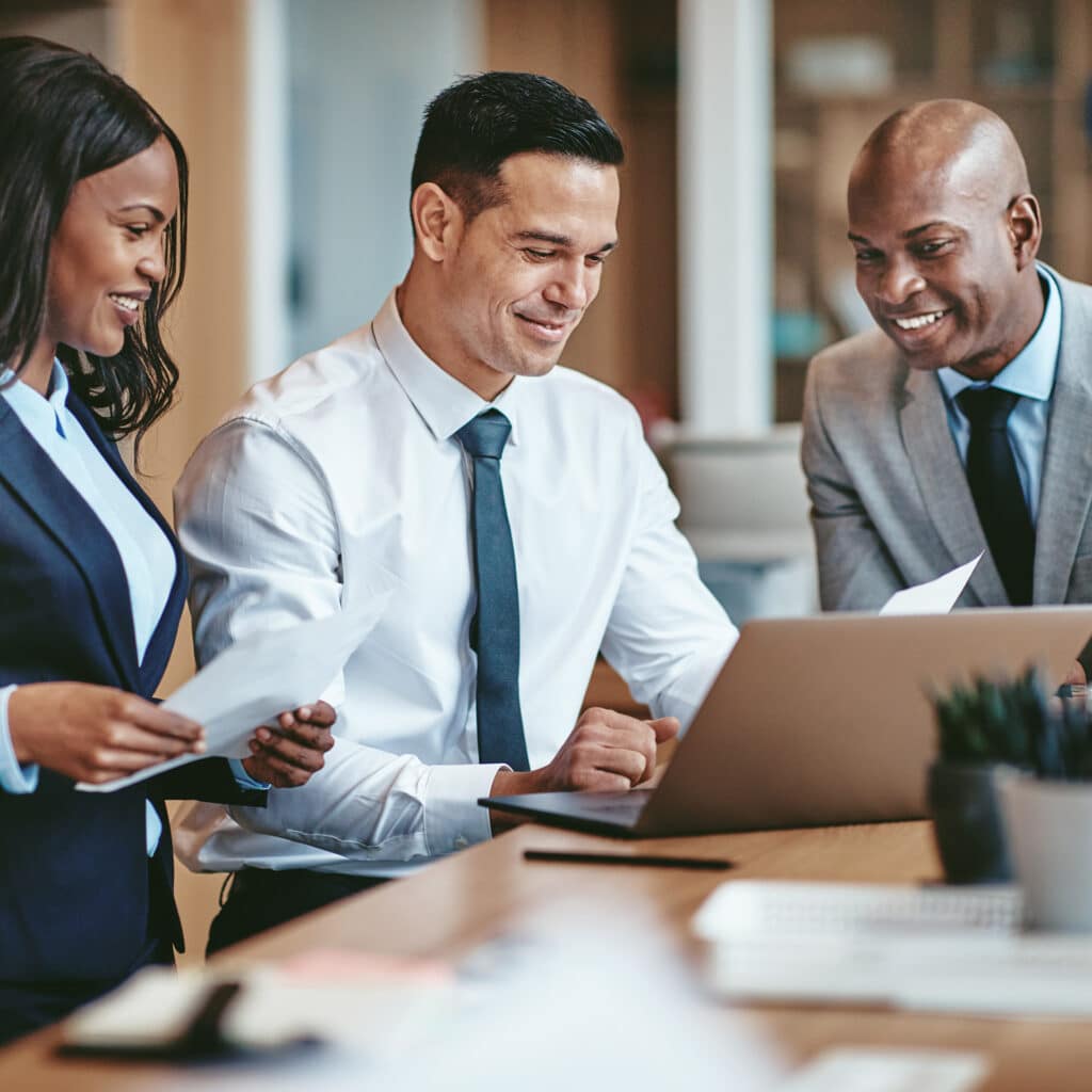 three business people looking at a laptop screen