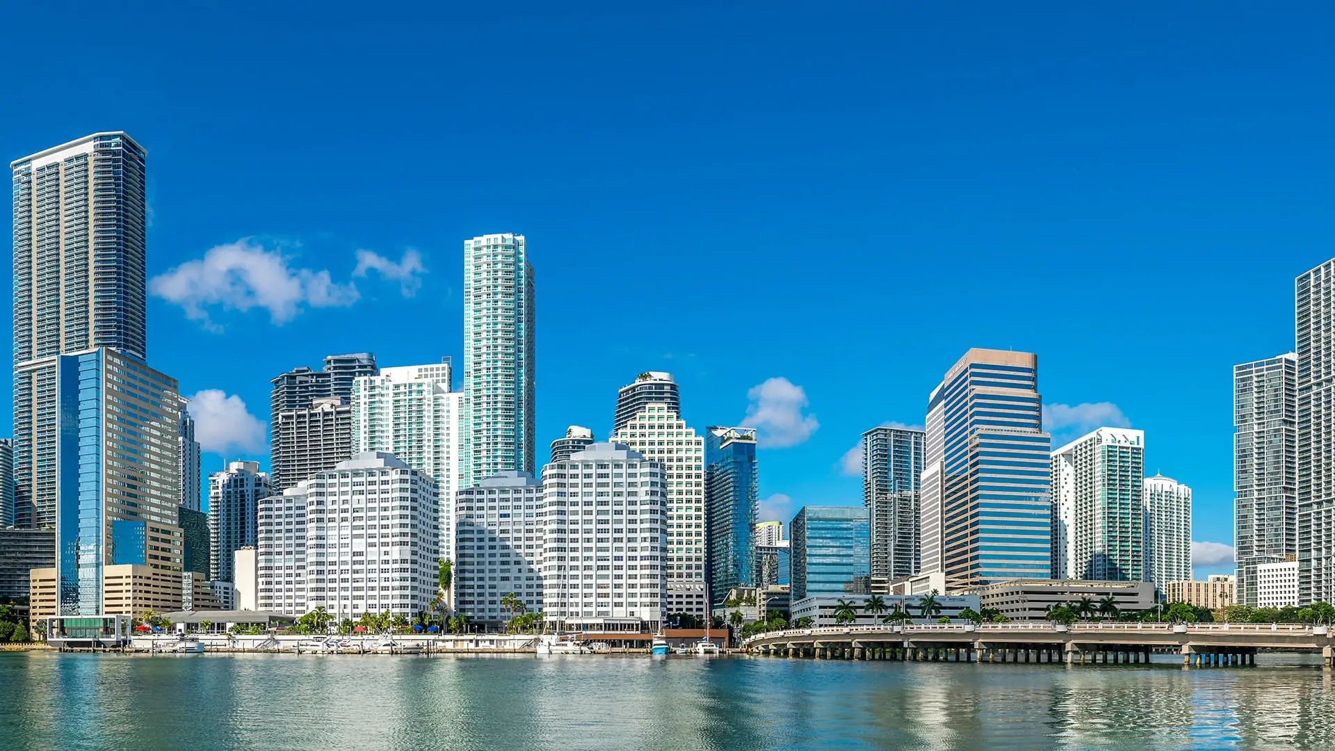 a city skyline with tall buildings on the water