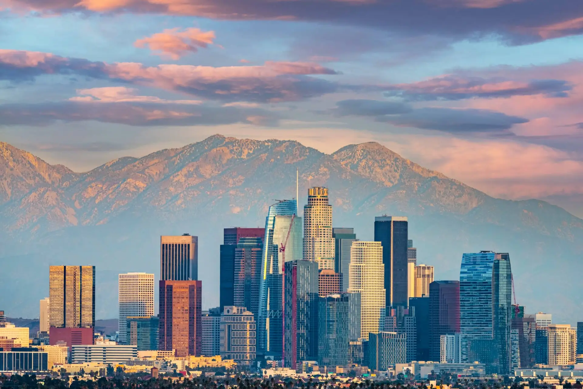 a city skyline with mountains in the background