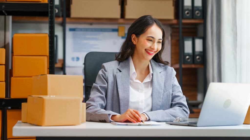 a woman sitting at a desk in front of a laptop