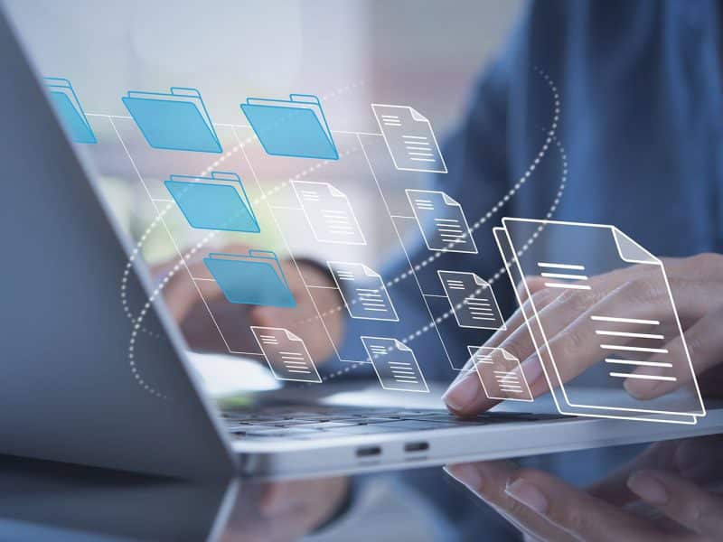 a person using a laptop computer with icons coming out of it